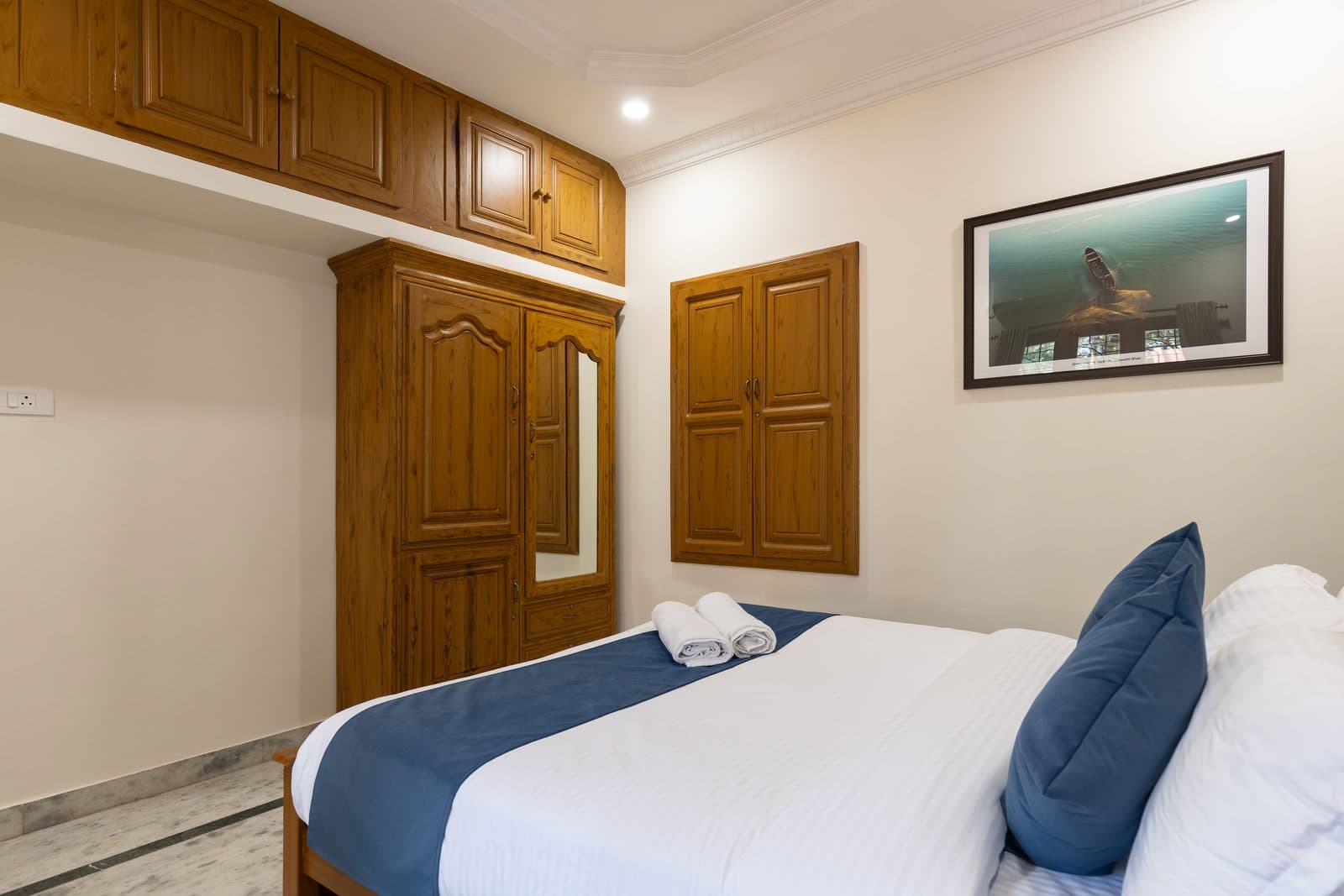 Room 2 from the head of the bed, with the wardrobe, the storage above it and the bird print