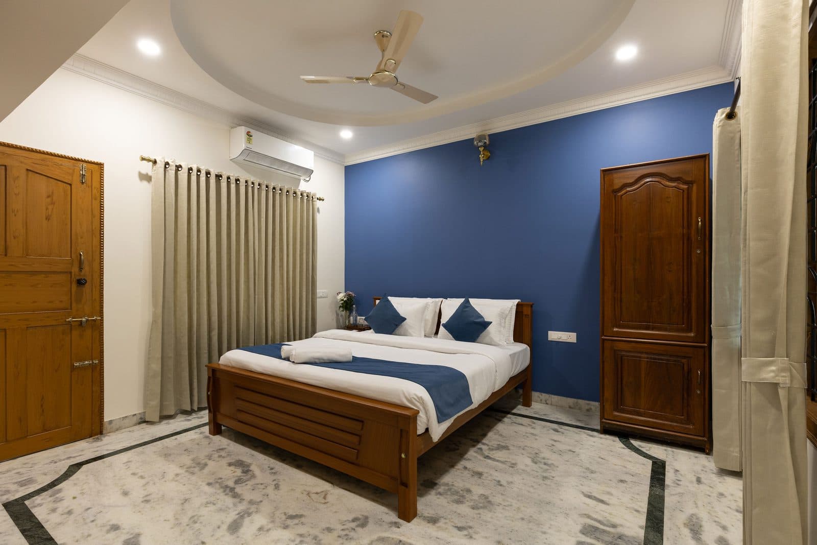 Room 4: a king bed against a blue wall, with the wardrobe beside the door