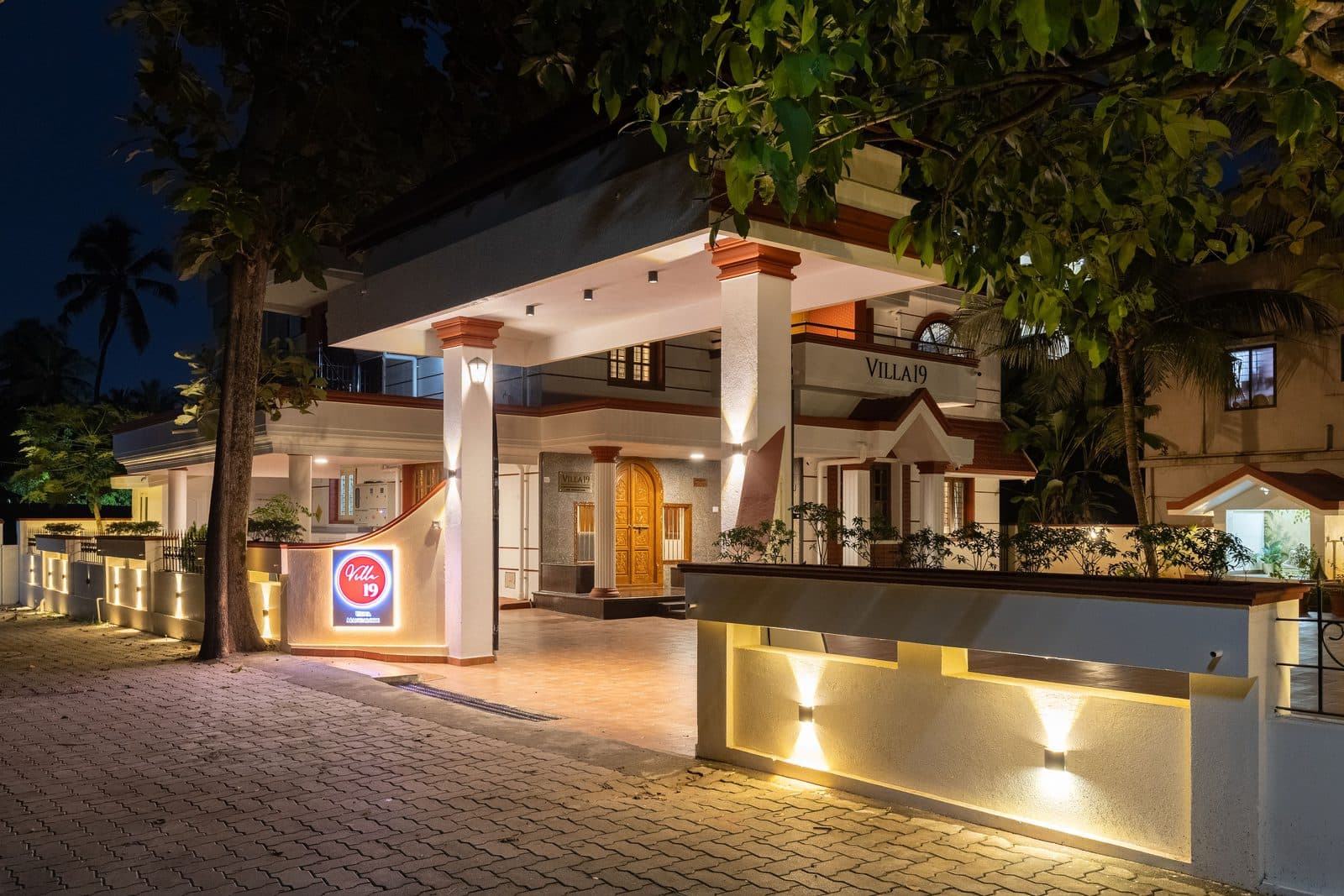 The entrance at night, with the lit porch and the driveway leading up to it