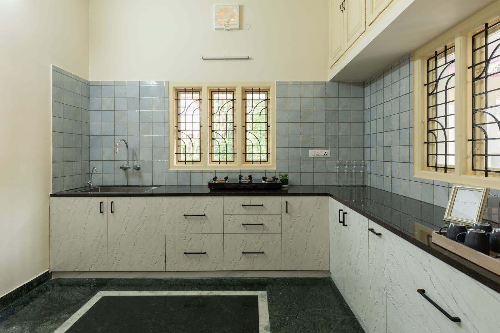 The kitchen, with a granite counter, a sink under the window and cupboards below