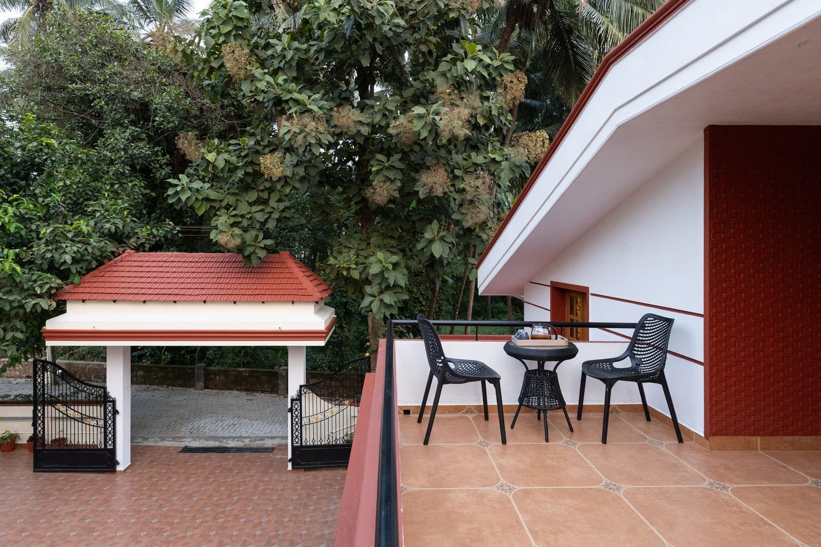 The first-floor sit-out, with a table and chairs looking out over the trees and the gate
