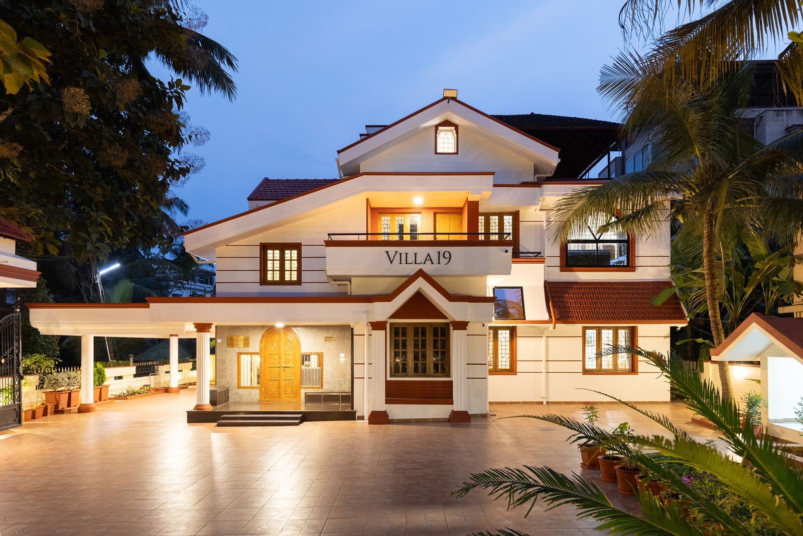 The front of the villa lit up at night, with the porch and the driveway in front of it